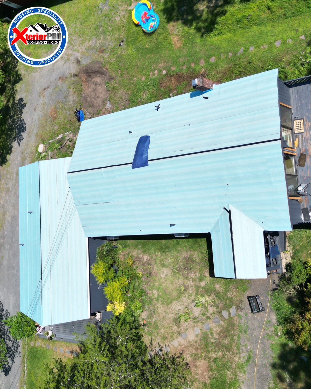 Overhead drone view of a residential roof tear-off showing synthetic underlayment during a roof replacement project